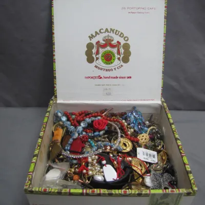 Sale Photo Thumbnail #41: Open Macanudo cigar box filled with assorted vintage fashion jewelry, including beaded necklaces, faux pearls, brooches, and earrings.