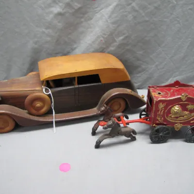 Sale Photo Thumbnail #100: Vintage handmade wooden model car paired with an antique cast iron lion circus wagon drawn by two horses, showing moderate wear and paint loss.