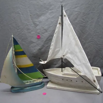 Sale Photo Thumbnail #124: Pair of vintage wooden sailboat models, featuring a colorful blue and green striped jib model and a larger whitewashed cabin cruiser with fabric sails.