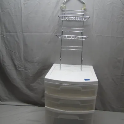 Sale Photo Thumbnail #238: White plastic three-drawer storage unit supporting a chrome hanging shower caddy with wire shelves and suction cups.