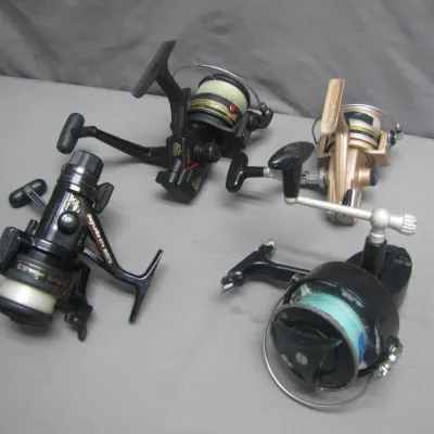 Sale Photo Thumbnail #272: Collection of four vintage spinning fishing reels, including Daiwa models, showing light wear from use.