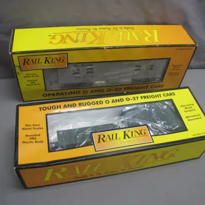 Sale Photo Thumbnail #259: Two boxed Rail King by MTH Electric Trains O and O-27 gauge freight cars, appearing unused in original window packaging.