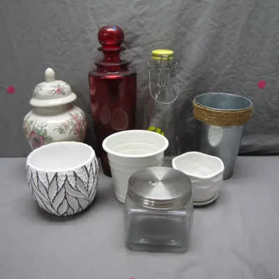 Sale Photo Thumbnail #152: Collection of decorative glassware and ceramic planters, including a red glass decanter, floral ginger jar, and small metal bucket.