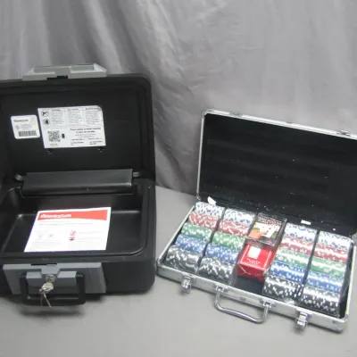 Sale Photo Thumbnail #274: Black SentrySafe fire-resistant lockbox with key alongside an aluminum briefcase filled with a poker chip set and playing cards.