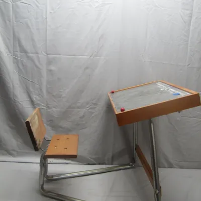 Sale Photo Thumbnail #217: Vintage children's school desk and chair combo featuring a tubular metal frame, wooden seat, and a sloped chalkboard desk surface printed with letters and numbers.