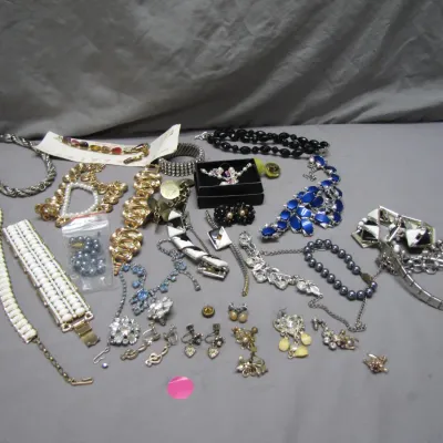 Sale Photo Thumbnail #62: Assorted vintage costume jewelry lot, featuring beaded necklaces, rhinestone brooches, clip-on earrings, and statement bracelets.