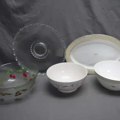 Sale Photo Thumbnail #90: Collection of vintage serveware, including a cherry-patterned glass bowl, clear glass cake stand, oval porcelain platter, and two ceramic mixing bowls.