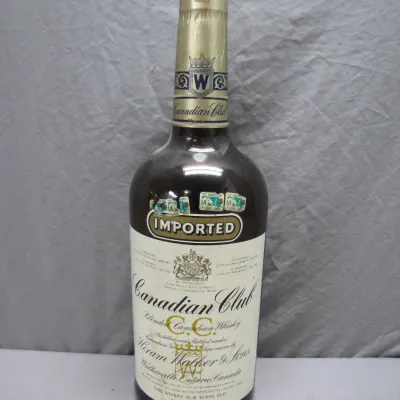 Sale Photo Thumbnail #160: Vintage Canadian Club Blended Canadian Whisky bottle by Hiram Walker & Sons, featuring original neck label and tax stamps.