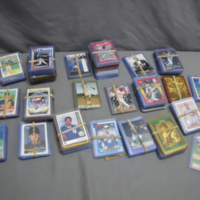 Sale Photo Thumbnail #261: Large collection of vintage baseball trading cards, mostly 1980s and 1990s editions, bundled in rubber bands and top loader protective cases.