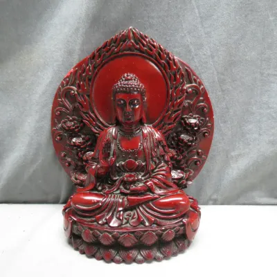 Sale Photo Thumbnail #3: Carved red resin or lacquer-style Buddha figurine seated on a lotus throne with an ornate flame mandorla backdrop.
