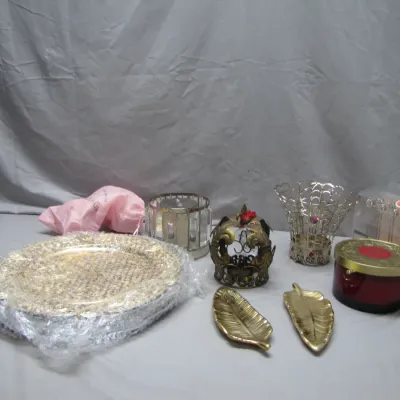 Sale Photo Thumbnail #44: Assortment of decorative home accents, including leaf-shaped brass trinket dishes, ornate candle holders, bubble-wrapped chargers, and a boxed set.