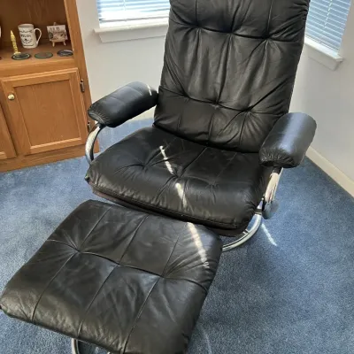 Sale Photo Thumbnail #51: Black leather tufted swivel recliner and matching ottoman with tubular chrome bases, late 20th century.