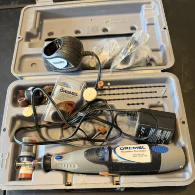 Sale Photo Thumbnail #12: Dremel MultiPro Cordless rotary tool kit, featuring model 780 9.6V tool, charger, base, and various grinding and cutting accessories in original hard plastic case.