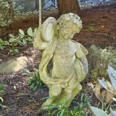 Sale Photo Thumbnail #52: Weathered concrete garden statue depicting a cherub playing cymbals, showing natural moss and patina from outdoor display.