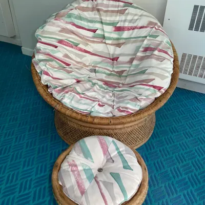Sale Photo Thumbnail #75: Vintage rattan papasan chair and matching ottoman featuring patterned pastel fabric cushions, circa 1980s.