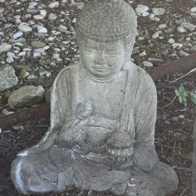 Sale Photo Thumbnail #48: Weathered concrete Buddha garden statue depicted in a seated position with a serene expression and draped robes.