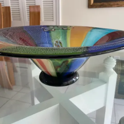 Sale Photo Thumbnail #36: Large Murano-style art glass bowl with a colorful abstract design and controlled bubble textured rim, resting on a glass table.