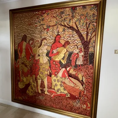 Sale Photo Thumbnail #34: Large framed batik or mosaic-style artwork featuring figures under a tree, housed in a thick gold-toned frame.