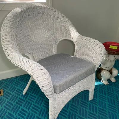 Sale Photo Thumbnail #76: White painted wicker armchair featuring a barrel back design paired with a grey upholstered seat cushion.