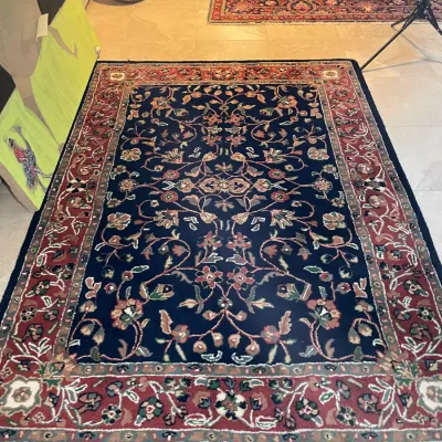 Sale Photo Thumbnail #9: Hand-knotted navy blue and red Persian-style area rug featuring an intricate floral vine motif with a ornate border.