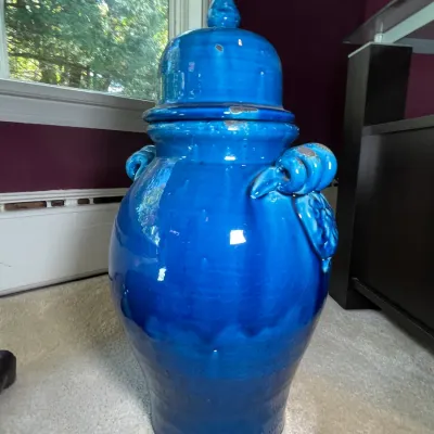 Sale Photo Thumbnail #31: Large vibrant cobalt blue glazed ceramic urn jar with lid and decorative side handles, showing minor paint chips near the rim.