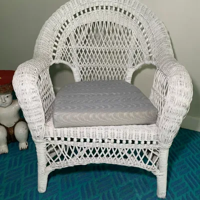 Sale Photo Thumbnail #73: Vintage white painted wicker armchair with a rounded back, open-weave details, and a removable grey seat cushion.