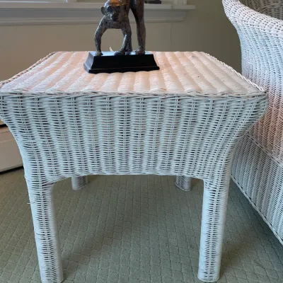 Sale Photo Thumbnail #55: White woven wicker side table topped with a bronze-tone monkey figurine on a black base.