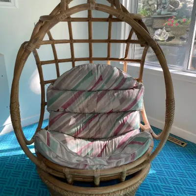 Sale Photo Thumbnail #74: Vintage bentwood rattan egg-style swivel pod chair featuring woven accents and a plush pastel-striped cushion.