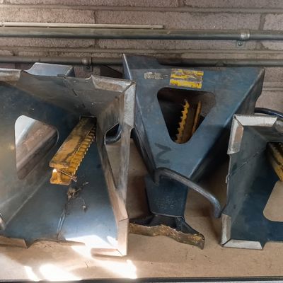 Set of four heavy-duty metal automotive jack stands, showing minor surface wear and paint loss.