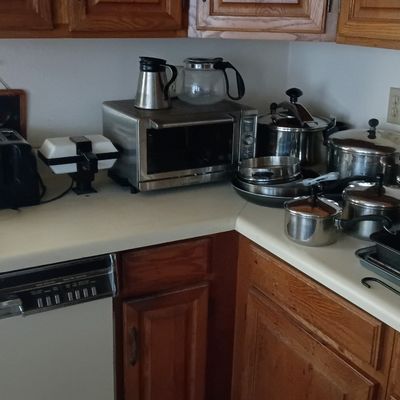 Collection of kitchen appliances and cookware, including a stainless steel Breville toaster oven, slow cooker, stainless stock pots,...