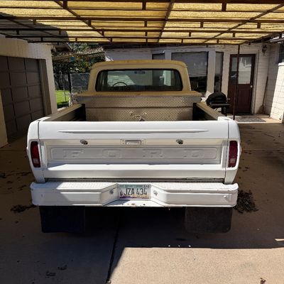Vintage white Ford pickup truck with a diamond-plate bed toolbox, parked under a carport.