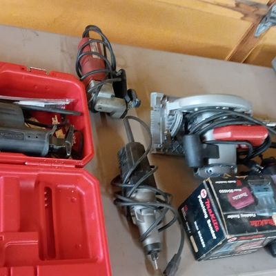Collection of power tools and hardware accessories, including a Milwaukee Sawzall in its red carrying case, a circular saw, a boxed...