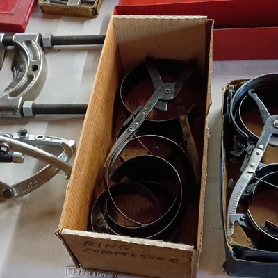 Selection of vintage automotive specialty tools, including piston ring compressors and gear pullers in original boxes.