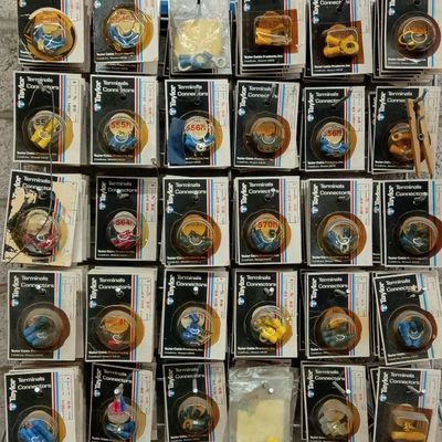 Vintage Taylor Cable brand electrical terminals and connectors in blister packaging displayed on a wire rack.
