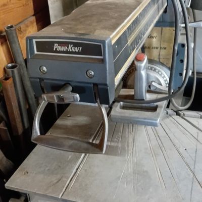 Vintage Powr-Kraft radial arm saw showing wear consistent with age and use.