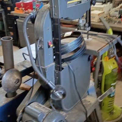 Craftsman Professional 14-inch band saw mounted on a metal stand, featuring an attached work light and spare blades.