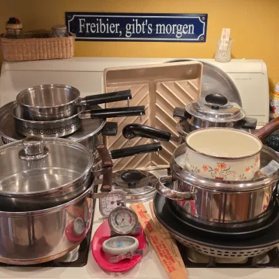 Sale Photo Thumbnail #30: Large assortment of cookware including stainless steel pots and pans, a floral enamel saucepan, roasting pans, and various kitchen thermometers.