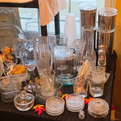 Sale Photo Thumbnail #43: Tabletop display featuring clear and cut glass vases, serving bowls, lidded candy dishes, coaster sets, and stainless steel canisters.