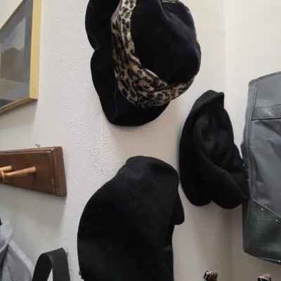 Sale Photo Thumbnail #148: Selection of vintage women's hats and handbags hanging on a wall alongside framed art and a peg rack.