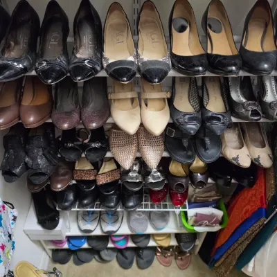Sale Photo Thumbnail #157: Collection of women's shoes arranged on a multi-tiered wire closet rack, including pumps, heels, flats, and sandals in various colors and styles.