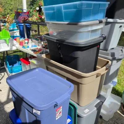 Sale Photo Thumbnail #339: Assortment of plastic storage totes and organization containers stacked outdoors alongside crafting supplies.