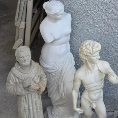 Sale Photo Thumbnail #348: Collection of three classical-style garden statues, including a Venus de Milo reproduction, Michelangelo's David, and a praying monk, showing light exterior wear.