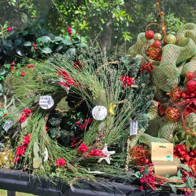 Sale Photo Thumbnail #335: Collection of assorted holiday wreaths and decor, including pine foliage, red berries, and mesh ribbon arrangements.