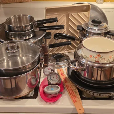 Sale Photo Thumbnail #29: Large assortment of cookware including stainless steel pots and pans, enamel floral saucepan, roasting tray, and kitchen thermometers.