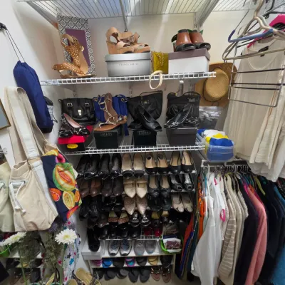 Sale Photo Thumbnail #153: Walk-in closet filled with women's clothing, handbags, and multiple tiers of shoes, including brands like Franco Sarto and Lauren Ralph Lauren.