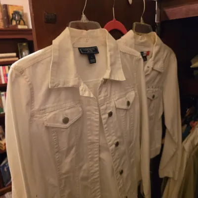 Sale Photo Thumbnail #256: Two white denim-style button-down jackets hanging on plastic hangers, including a Charter Club brand jacket.