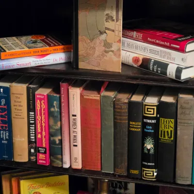 Sale Photo Thumbnail #193: Collection of hardback books including vintage reference, history, and self-help titles arranged on wooden bookshelves.
