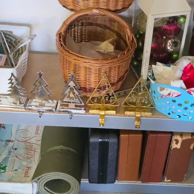 Sale Photo Thumbnail #293: Selection of home decor items including Christmas tree stocking holders, woven baskets, a glass lantern filled with ornaments, and vintage carrying cases.