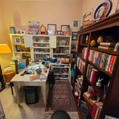 Sale Photo Thumbnail #213: Home office setup featuring a white craft desk, modular hutch shelving unit, tall dark wood bookcase, and traditional area runner rug.