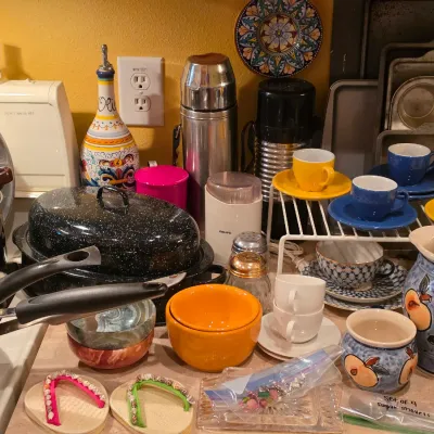 Sale Photo Thumbnail #27: Collection of kitchen items including colorful teacups with saucers, speckled granite roasting pans, stainless steel thermos bottles, and ceramic pottery.